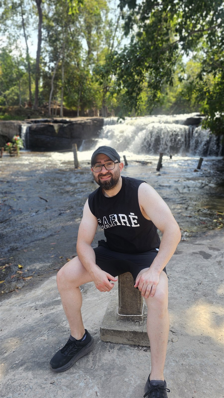 Joseph Bitar sitting beside a waterfall during time outdoors