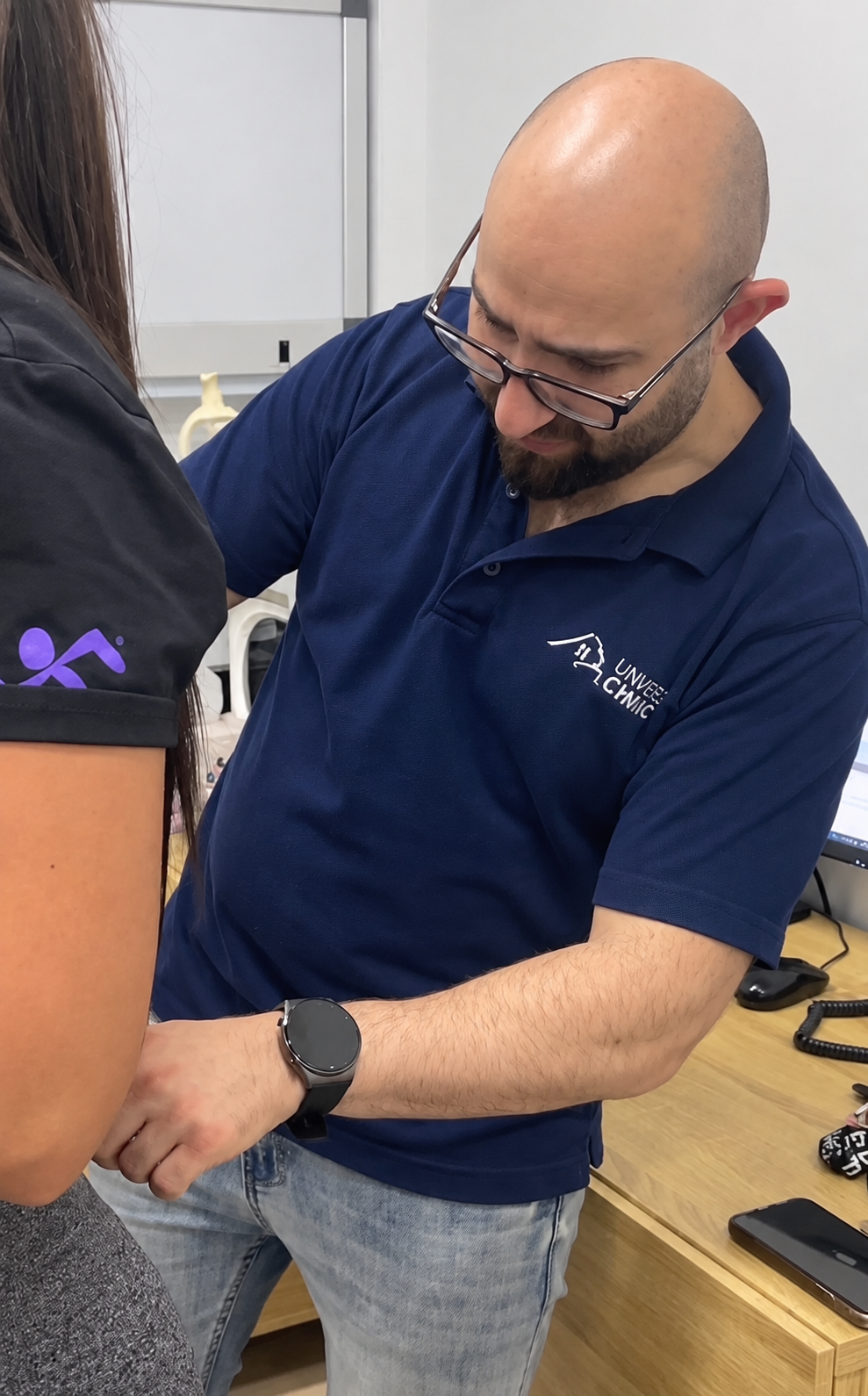 Joseph Bitar providing hands-on care; the patient is shown without her face
